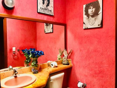 a red bathroom with a sink and a mirror at Sunset Double Room in Stunning Villa Playacar Ii in Playa del Carmen