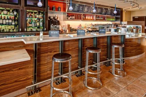 ミッドランドにあるCourtyard by Marriott Midlandのスツールのあるレストランのバー