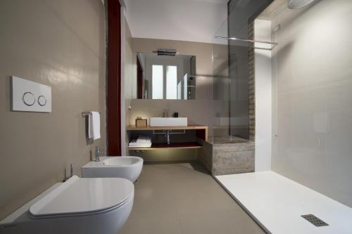 een badkamer met een toilet, een wastafel en een spiegel bij Atypical Rooms in Rome
