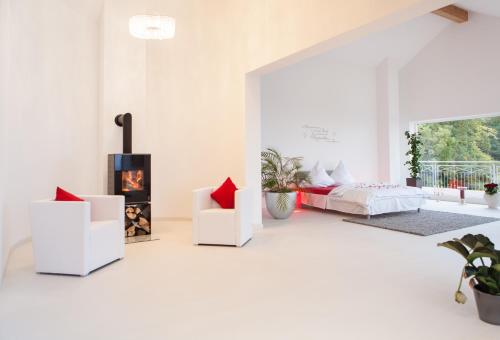 a white living room with a bed and a fireplace at Schöne Aussicht in Alzenau in Unterfranken