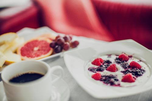 a cup of coffee and a plate of food with fruit at Best Western Hotell Lerdalshoejden in Rättvik
