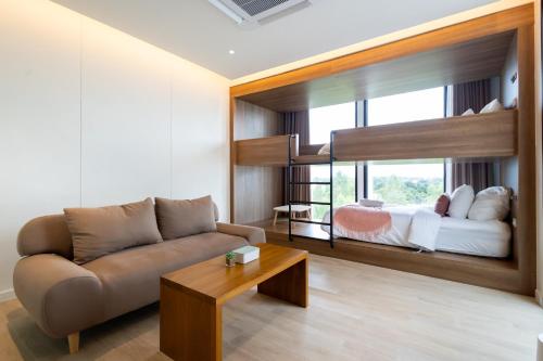 a living room with a couch and a bunk bed at GOOD Nakhonsawan Hotel in Nakhon Sawan