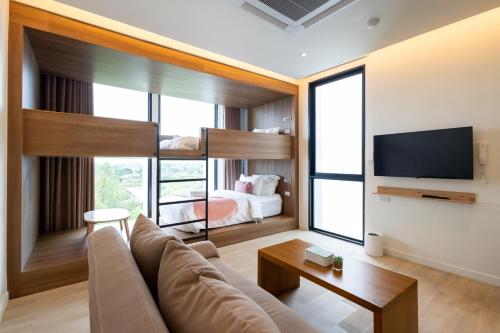 a living room with a couch and a bed at GOOD Nakhonsawan Hotel in Nakhon Sawan