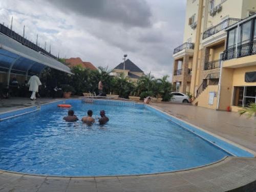 a group of three men sitting in a swimming pool at Nippon Grand Hotels - Classic in Jabi