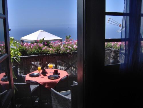 イコー・デ・ロス・ビノスにあるModern holiday home with balcony with sea and mountain views - no Teide-viewのバルコニー(テーブル、グラスと皿付)