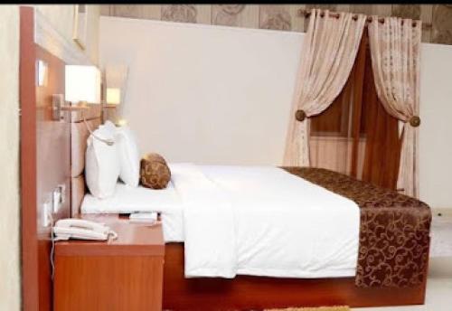 a bedroom with a bed and a nightstand with a phone at Nippon Grand Hotels - Grand Suite in Jabi