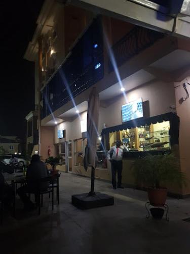 a man walking in front of a store at night at Nippon Grand Hotels - Grand Suite in Jabi