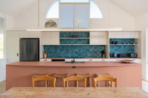 a kitchen with a counter with chairs in it at Eureka in Boomerang Beach