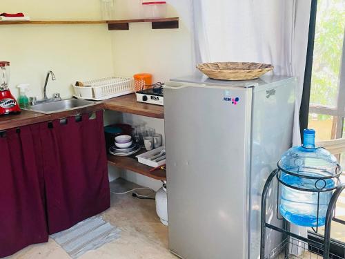 a kitchen with a refrigerator and a sink at Double Bed, Queen size, small kitchen, terrace, wi fi air condition quiet in Cuatunalco