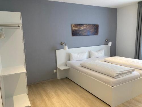 a small bedroom with a white bed and a closet at Hotel-Fritz in Valwig