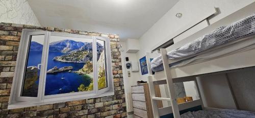 - une chambre avec une grande fenêtre offrant une vue sur la montagne dans l'établissement Entire apartment 200 meters from the seaside Au BleuRivage, à Ensuès-la-Redonne