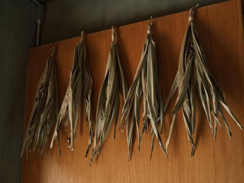 a row of hanged feathers hanging on a wall at Negura in Ujimi