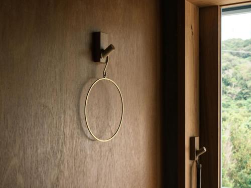 a round mirror hanging on a wall next to a window at Negura in Ujimi