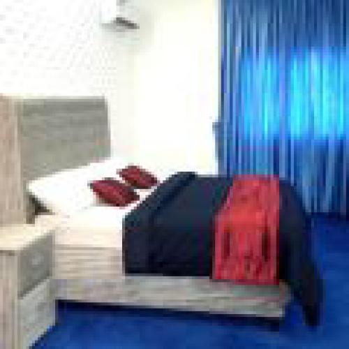 a minecraft bedroom with a bed with a red blanket at Adanma Hotel and Suites in Abuja
