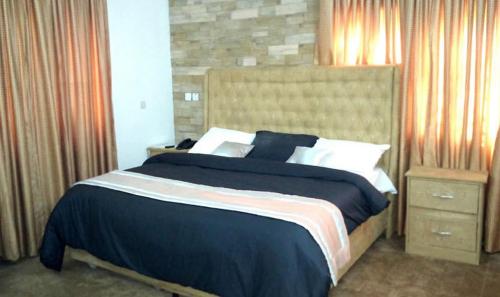 a bedroom with a large bed with black and white pillows at Adanma Hotel and Suites in Abuja