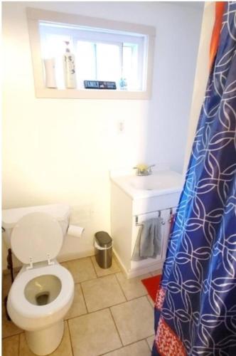 a bathroom with a toilet and a sink and a window at Black-white Rm By Yale U in New Haven