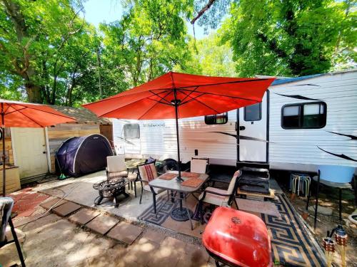 a patio with a table and an umbrella and a trailer at Black-white Rm By Yale U in New Haven