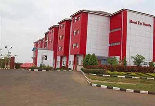 a row of red and white buildings in a parking lot at Hotel De Bently - Deluxe in Abuja