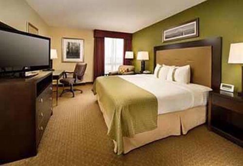 a hotel room with a large bed and a flat screen tv at Hotel De Bently - Deluxe in Abuja