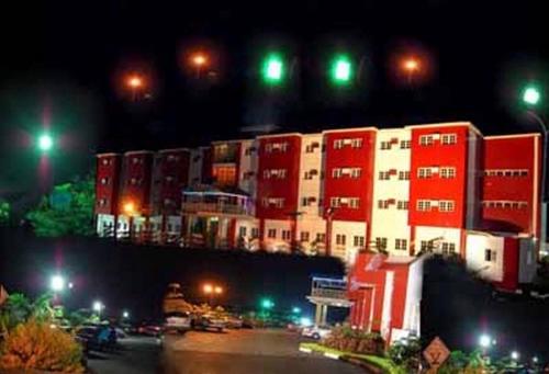 a large red and white building at night at Hotel De Bently - Deluxe in Abuja