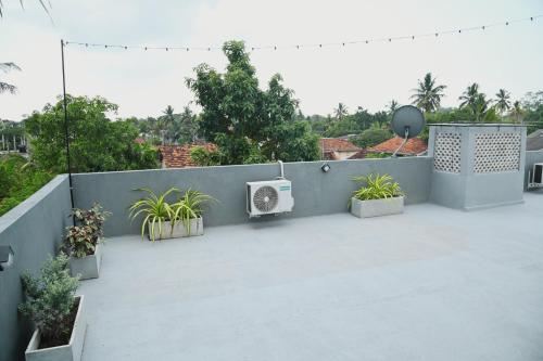 a patio with potted plants and a fence at Wind Villa Weligama in Weligama