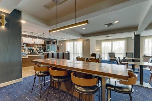 a cafeteria with a large wooden table and chairs at Courtyard Lexington South/Hamburg Place in Lexington
