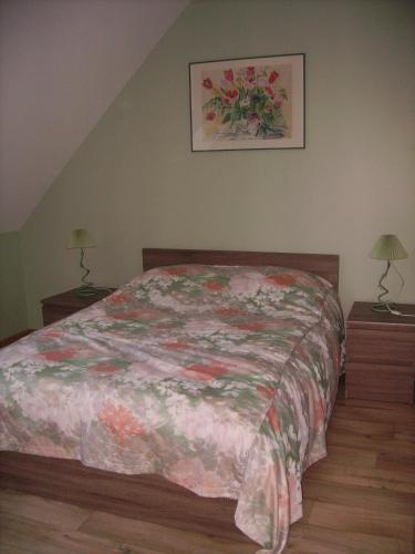 une chambre avec un lit et deux tables de nuit avec lampes dans l'établissement La Grimodière Gîte, à Ranville