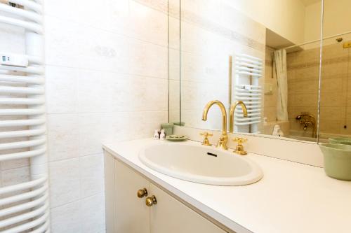 a bathroom with a sink and a mirror at Heart Milan Apartments Duomo Castello in Milan