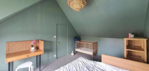Cette chambre mansardée comprend un lit, un bureau et un lit bébé. dans l'établissement Maison Le repos des pêcheurs, à Quiberon