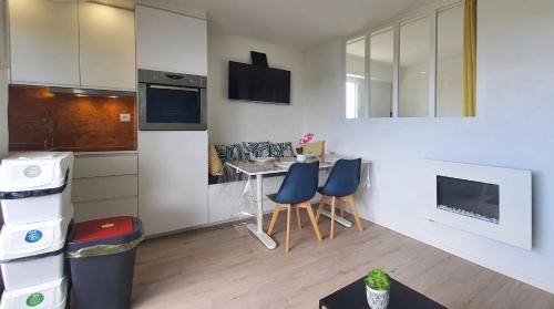 - une cuisine avec une table et des chaises bleues dans la chambre dans l'établissement Bleu Horizon, à Quiberon