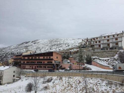 a group of buildings in the snow with a mountain at Hotel Campo Felice in Lucoli Alto