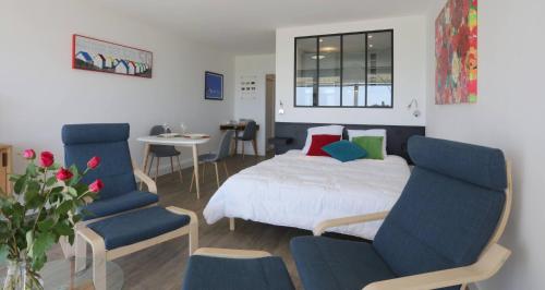 une chambre avec un lit, deux chaises et une table dans l'établissement Studio Vue Mer Evasion Marine, à Quiberon
