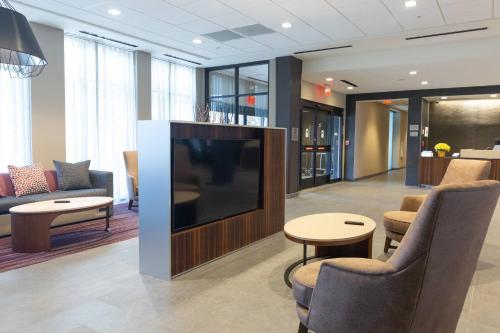 a lobby with a flat screen tv and chairs at Courtyard by Marriott Cartersville in Cartersville