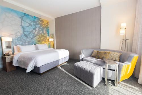 a hotel room with a bed and a couch at Courtyard by Marriott Cartersville in Cartersville