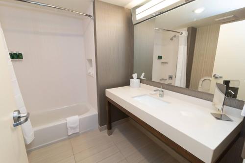 a bathroom with a sink and a tub and a mirror at Courtyard by Marriott Cartersville in Cartersville