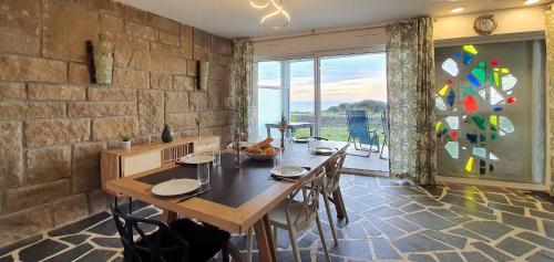 une salle à manger avec une table et une grande fenêtre dans l'établissement Maison Vue Mer Les Moinillons, à Quiberon