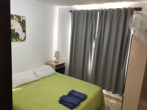 a bedroom with a green bed and a window at WaraKusi Cottages - Off Road in Salta