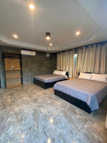 a bedroom with two beds and a marble floor at ชมดอยรีสอร์ท in Chiang Dao