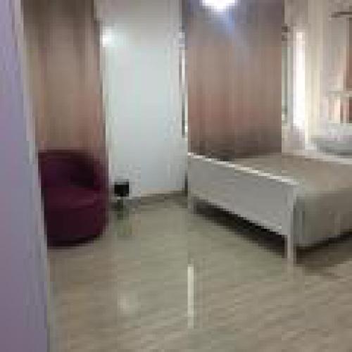 a bedroom with a white bed and a door at Royal Signature Suites and Apartments in Ibadan