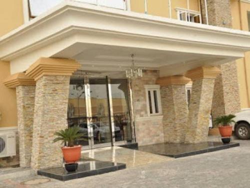a building with a large entrance with potted plants at Nippon Grand Hotels - 3 Bd Apartment in Jabi