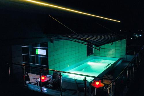 a swimming pool at night with chairs and lights at Limewood Hotel - Classic in Port Harcourt