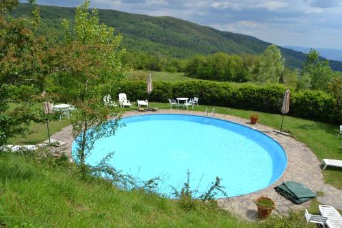 una piscina en un patio con sillas y mesas en Two-room apartment in Tuscany country style, en La Lama