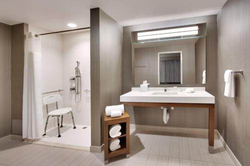 a bathroom with a sink and a mirror at Courtyard by Marriott Atlanta Duluth Downtown in Duluth