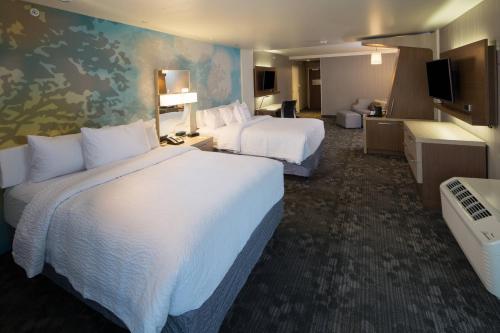 a hotel room with two beds and a television at Courtyard Bay City in Bay City