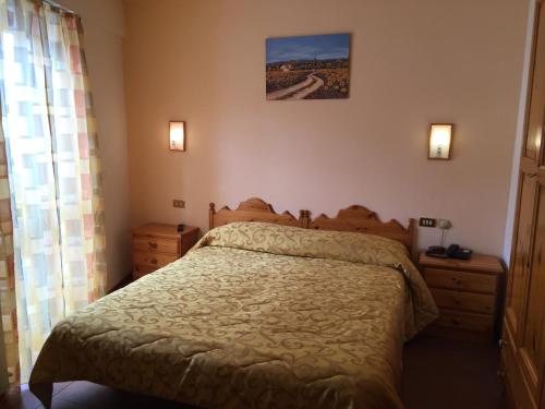 a bedroom with a bed and a picture on the wall at Hotel Campo Felice in Lucoli Alto
