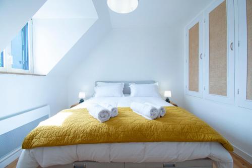 a bedroom with a bed with towels on it at Nid de Granit I Plage & Terrasse in Crozon