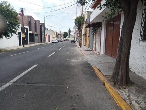 an empty street with a tree on the side of the road at Apartamento Cntrico Vive El Pulsar De La Ciudad in Toluca