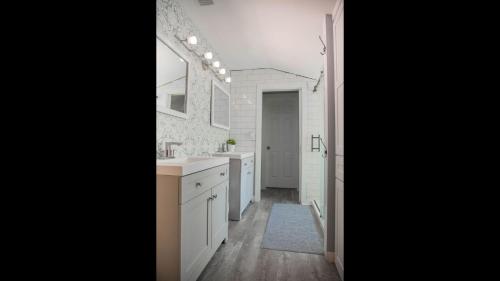 a white bathroom with a sink and a mirror at Family Home with Private Pool Yard Only 24 Mi to Disney in Saint Cloud