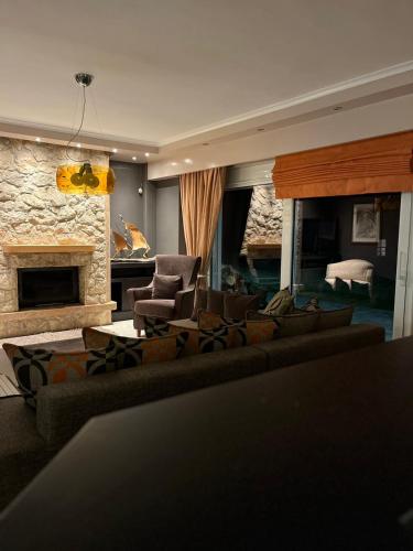 a living room with couches and a stone fireplace at Luxury Heaven farm one in Kastoria