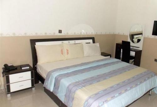 a bedroom with a bed and a desk with a mirror at Goldenland Hotels - Executive in Asaba